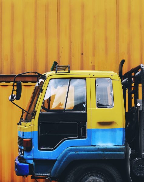 Yellow truck parked near a yellow container box